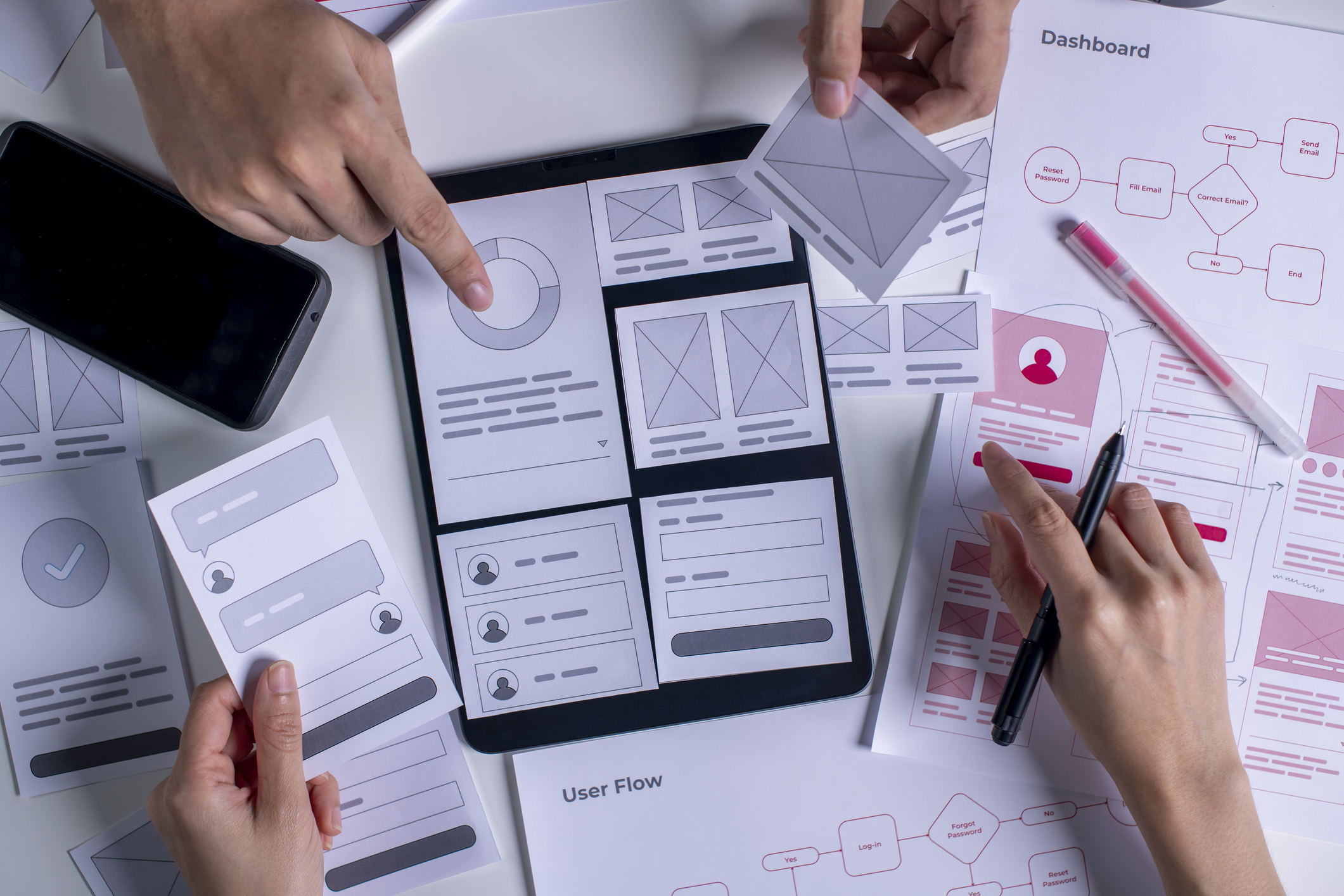UX/UI Design Close up UX developer and UI designer brainstorming about mobile app interface wireframe design on table.