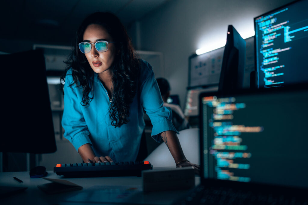 Tech Due Diligence image of a woman working with several computers running code